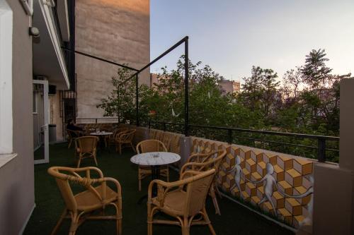 a patio with tables and chairs on a balcony at Athens Hawks in Athens