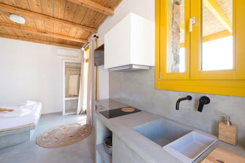 a kitchen with a sink and a yellow cabinet at Themonies Suites and Apartments in Kithnos