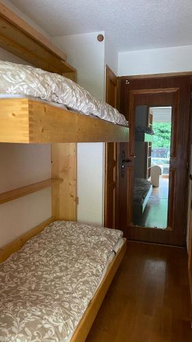 une chambre avec un lit superposé et un miroir dans l'établissement Cosy studio on the slopes and centre of Chamonix, à Chamonix-Mont-Blanc