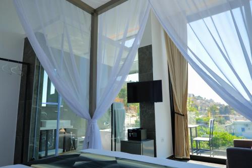 1 dormitorio con cama y ventana grande en Nili Deluxe, en Sarandë