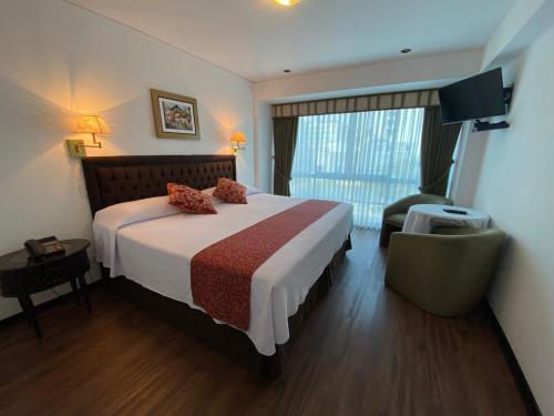 une chambre d'hôtel avec un lit et une chaise dans l'établissement Hotel Monte Real, à Lima