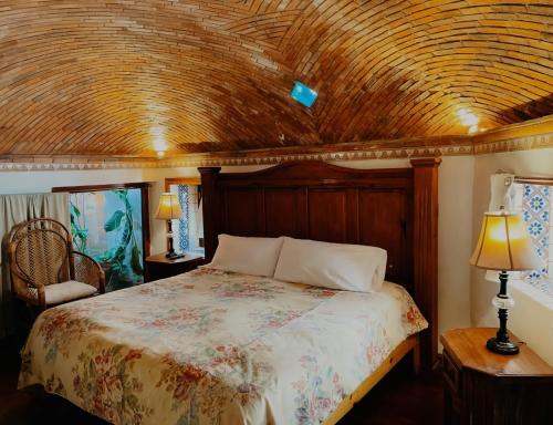 a bedroom with a bed with a wooden ceiling at Casa de Pita in Guanajuato