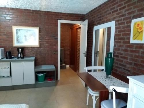 a kitchen with a table and a brick wall at Apartamento no Centro de Gramado in Gramado