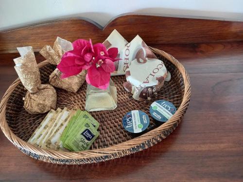 a basket filled with cookies and a vase with flowers at Luxury Suites Vila Indonésia in Garopaba