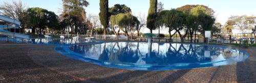 a large blue fountain in a park with trees at Palmares Apart Termal in Termas de Guaviyu