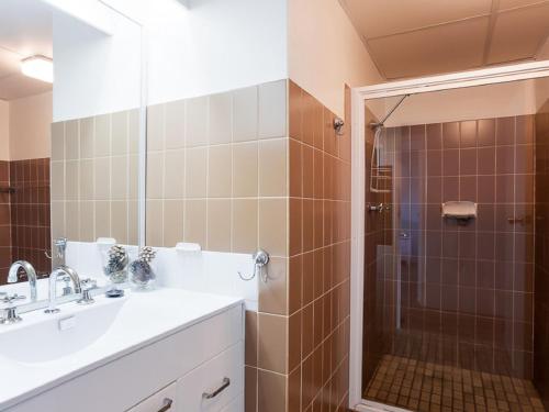 a bathroom with a sink and a shower at The Commodore, 23,9-11 Donald Street - Delightful unit with gorgeous water views, air con and wi-fi in Nelson Bay