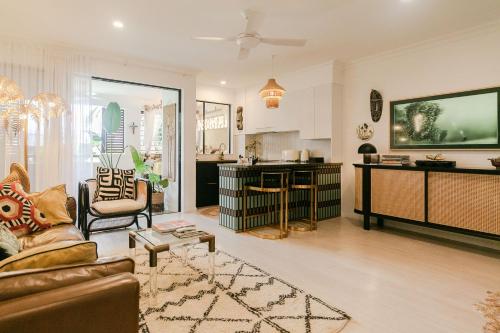 a large living room with a couch and a kitchen at NOMAD - Luxe apartment in Port Douglas