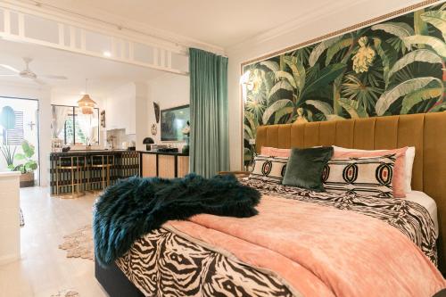 a bedroom with a large bed with a large wall mural at NOMAD - Luxe apartment in Port Douglas