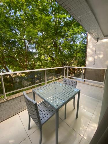 ジョアンペソアにあるPrédio Solar do Atlântico - Apartamento lateral em Tambaúの木々のあるバルコニー(テーブル、椅子付)