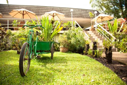 a green bike parked in the grass in front of a house at Bird Of Paradise Hotel in Goroka