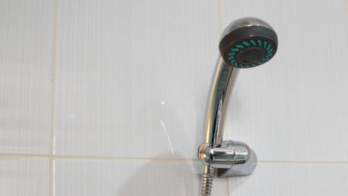 un cabezal de ducha en la pared del baño en Hostel 18 Pasangan Butuh Surat Nikah en Bandung