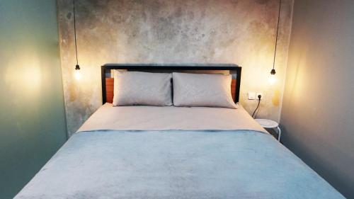 1 cama con 2 almohadas blancas en una habitación en Hostel 18 Pasangan Butuh Surat Nikah en Bandung