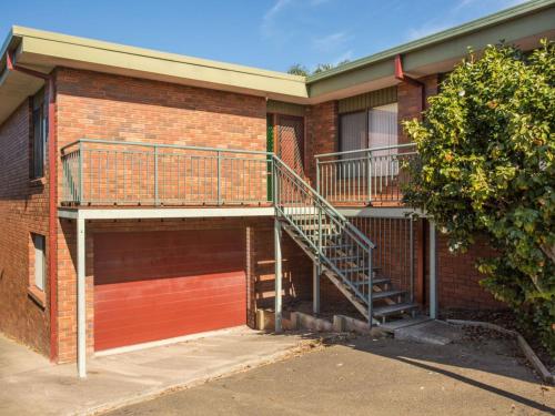 una escalera en el lateral de un edificio de ladrillo en Fishermans Lodge, en Merimbula