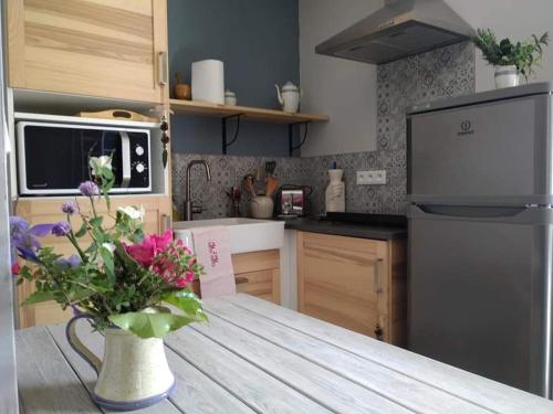 una cocina con una mesa con un jarrón de flores en Atelier Benjaminte, en Maillane