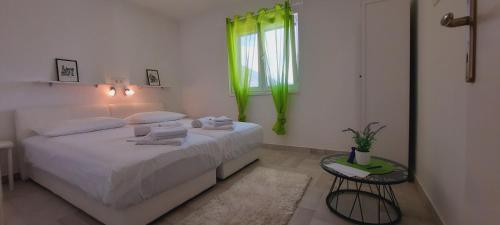 科米扎Apartments SUHO Komiza的一间带床和窗户的白色卧室