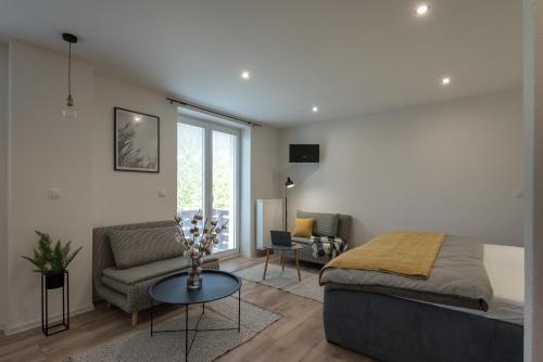 a bedroom with a bed and a couch and a table at Symple apartments in Košice