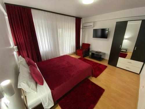 a bedroom with a red bed and a mirror at Oriana in Constanţa