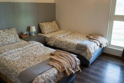 1 dormitorio con 2 camas y mesa con lámpara en مزرعة ومنتجع (منتجع غضي) en Aḑ Ḑalfa‘ah