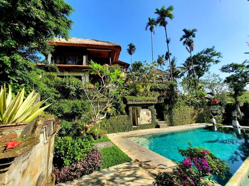 a house with a swimming pool in front of a yard at Alam Indah Ubud in Ubud