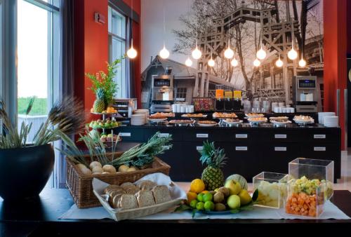 un buffet con frutas y verduras en una mesa en Domina Milano Fiera, en Novate Milanese