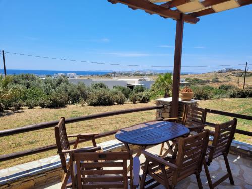 a table and chairs on a balcony with a view of the ocean at Aigaio Studios tinos in Tinos Town