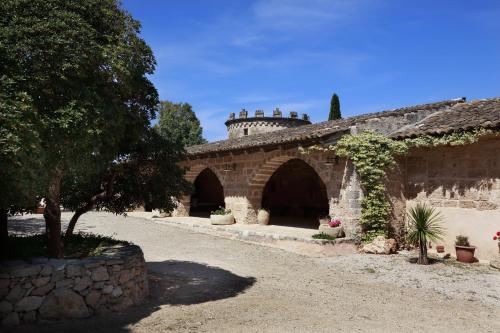 a stone building with a tree and a stone wall at Masseria Nucci - Autentica Dimora Storica in Nardò