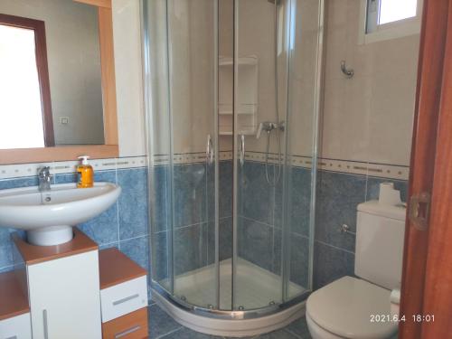 ein Bad mit einer Dusche, einem WC und einem Waschbecken in der Unterkunft A Casiña do Miramar in A Lanzada