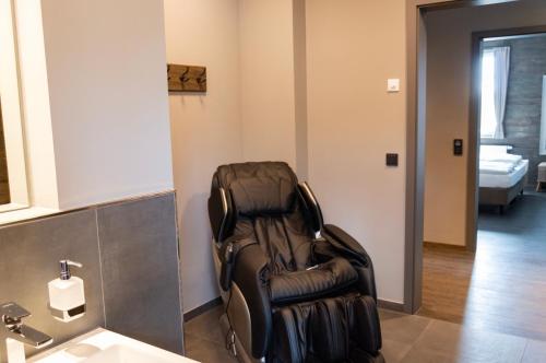 a leather reclining chair sitting in a bathroom at StrandBerg's Ursprung: Spa & Kitchen in Braunlage