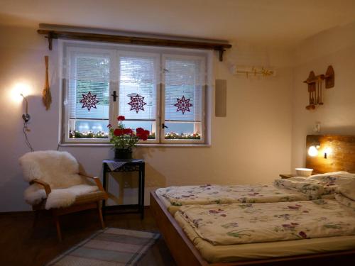 a bedroom with two beds and a window and a chair at Farmer's Room at Sedliacky Dvor - Brezno in Brezno