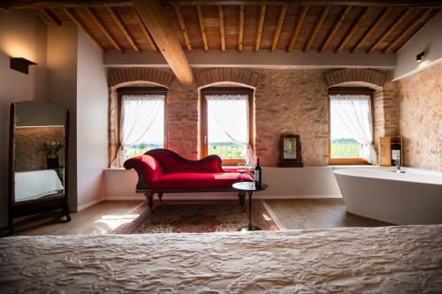 a bathroom with a tub and a red couch and a bath tub at Magari Estates Hotel in Colognola ai Colli