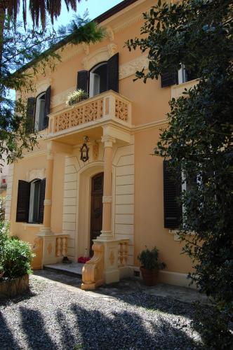 a yellow house with a balcony on the front of it at Arena Alfieri B&B in Livorno