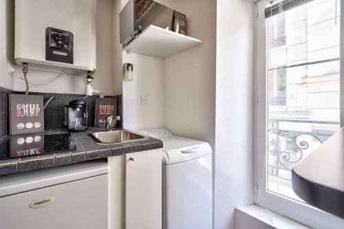 une petite cuisine avec un évier et un micro-ondes dans l'établissement Cute and New Studio Duplex in the Heart of Paris, à Paris