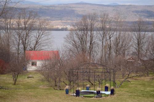 a playground in the middle of a field next to a house at Gîte au Toit Bleu in Sainte-Famille