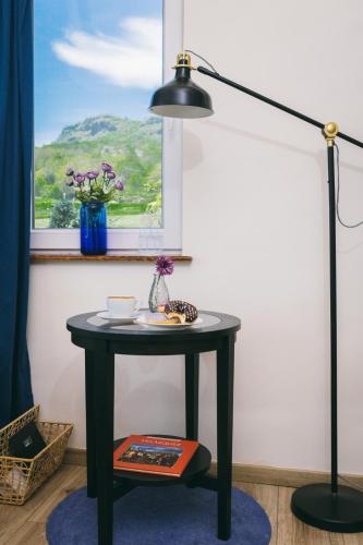 a black table with a lamp and a window at Dandelion Vendégházak in Kisapáti