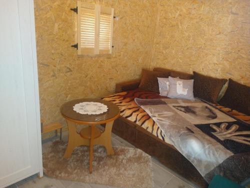 a small bedroom with a bed and a table at Ranczo u Jarka in Jeżyce