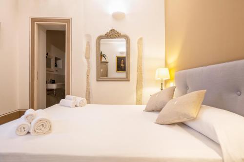a bedroom with a large white bed with towels on it at Casa Modica - Luxury rooms in Noto