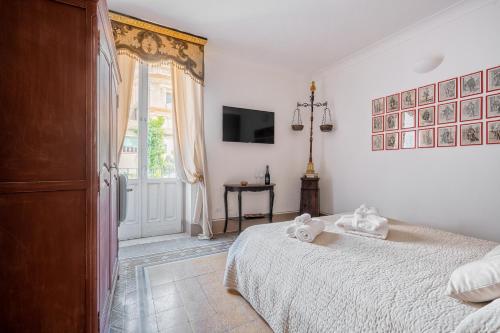 a bedroom with a bed and a window and a tv at Casa Modica - Luxury rooms in Noto