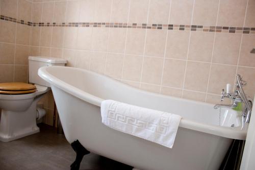 a white bath tub in a bathroom with a toilet at Kings Arms in Thirsk