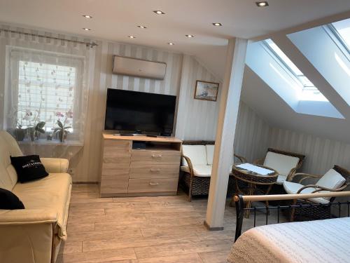 ein Wohnzimmer mit Flachbildfernseher und Couch in der Unterkunft Apatamentas Nidos centre in Nida