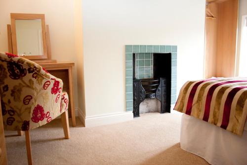 a living room with a bed and a fireplace at Kings Arms in Thirsk