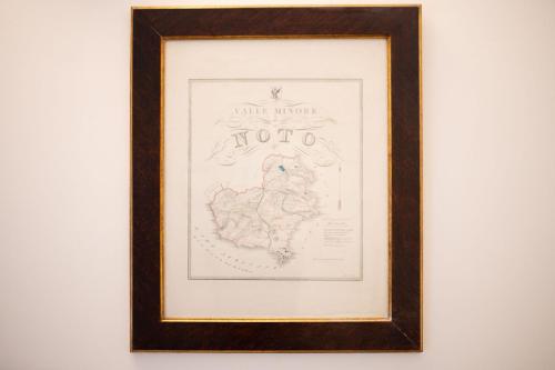 a drawing of a bird in a frame on a wall at Casa Modica - Luxury rooms in Noto