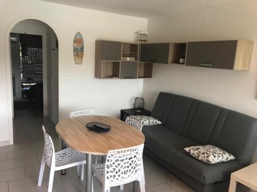 un salon avec un canapé et une table dans l'établissement Marinas et mer 25, à Saint-Cyprien