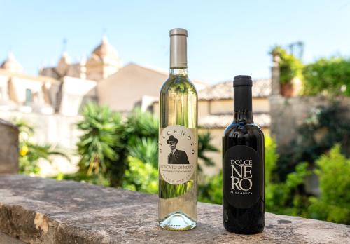 two bottles of wine sitting on a ledge at Casa Modica - Luxury rooms in Noto