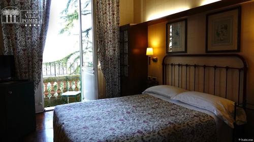 a bedroom with a bed and a large window at Relais Villa Pomela in Novi Ligure