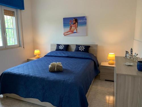 una camera da letto con un letto con un piumone blu di Villa Antonietta By Cala Salento a Punta Prosciutto