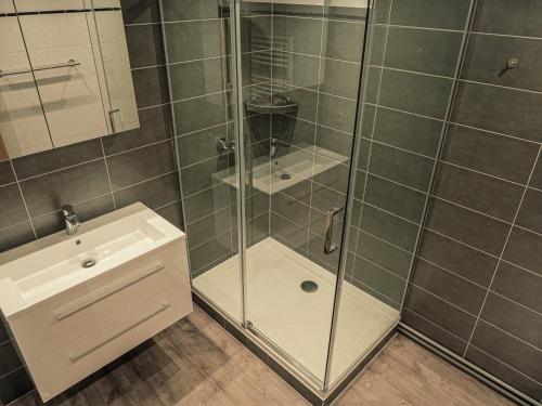 a shower with a glass door next to a sink at The Hunting Lodge in Landry