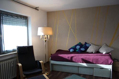 een slaapkamer met een paars bed en een stoel bij Unique Appartement Sulzfeld am Main in Sulzfeld am Main
