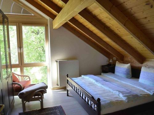 ein Schlafzimmer mit einem großen Bett im Dachgeschoss in der Unterkunft Ferienhaus Christel in Bad Urach