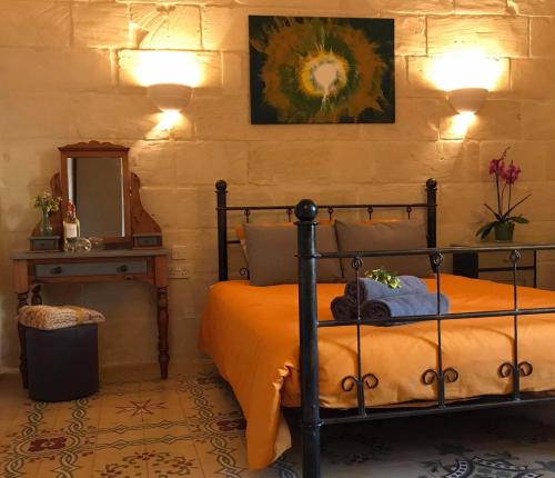 sypialnia z łóżkiem i lustrem w obiekcie Ta Marie Merhba w mieście Żebbuġ