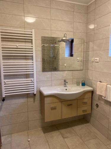 ein Bad mit einem Waschbecken und einem Spiegel in der Unterkunft Apartment Mare Krk in Milohnići
